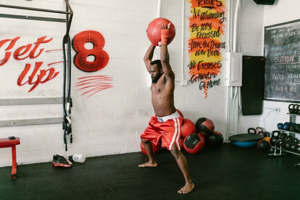 Man slams the medicine ball on the ground to increase power and punches speed.